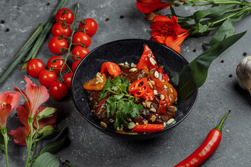 Beef wok. Traditional chinese mongolian beef stir fry in chinese cast iron wok with cooking chopsticks, stone slate background. Top view, copy space