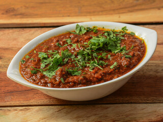 Mutton kheema curry or lamb kheema curry, spicy and delicious dish served over a rustic wooden background, selective focus