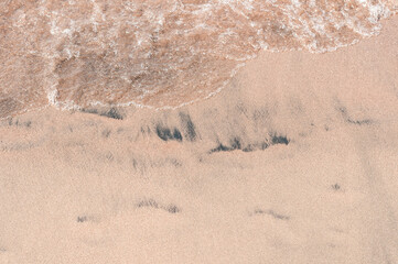 Transparent sea waves on the warm sandy seashore. Sea vacation and travel.