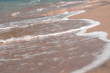 Transparent sea waves on the warm sandy seashore. Sea vacation and travel.