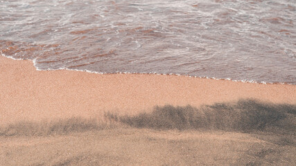 Transparent sea waves on the warm sandy seashore. Sea vacation and travel.