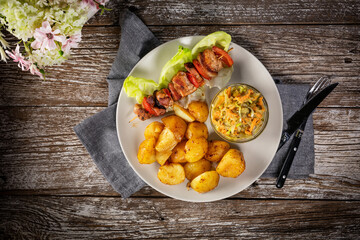 Shish kebab served with roasted potatoes and salad.