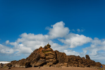 Fototapeta na wymiar Teenager stands on top an intertidal rock
