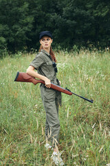 Woman soldier A woman with a weapon in her hands in a green jumpsuit look to the side 