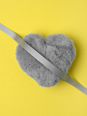 Heart shaped fluffy toy in trendy ultimate gray on illuminating background. Valentine's Day, love and happiness concept. Main colours of the year 2021.