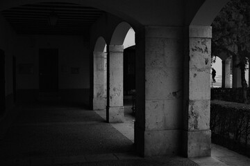 Black and white shot from a dark building with arches