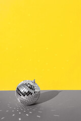 Disco ball with background in trending colors of 2021 - gray and yellow.