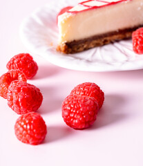 Cheesecake with red raspberries on pink backdrop