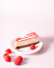 Cheesecake with red raspberries on pink backdrop