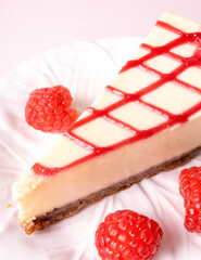 Cheesecake with red raspberries on pink backdrop