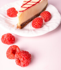 Cheesecake with red raspberries on pink backdrop
