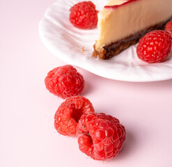 Cheesecake with red raspberries on pink backdrop