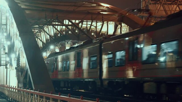 Train leaves goes over the Andreevsky bridge over the Moscow river in Moscow, Russia, in the evening of 27.11.2021
