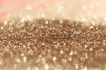 Beige gold glitter glow background. Rose gold shiny texture.New Year and Christmas background.Wallpaper phone shining glitter.glitter macro background with shining bokeh.