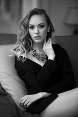 Closeup portrait of a young woman in black classic suit. Black and white photo. Looking at camera.
