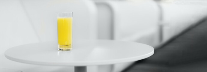 Gray sofa, table, glass of yellow juice. Minimalistic style outdoor interior. Demonstrating trendy Color of the Year 2021. Illuminating Yellow, Ultimate Gray. Duotone. Depression treatment. Banner
