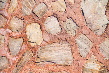 Red wall made of large processed light stones and clay and cement as an abstract background