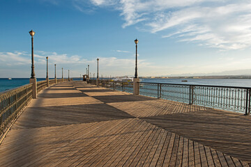 View down a wooden jetty pier in tropical seaside resort