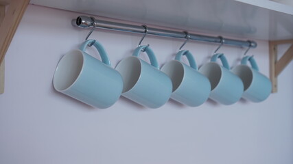Coffee Cups Hanging on Rack.