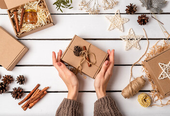 A woman is packing gifts in a craft box. Eco friendly Christmas. Wasteless.