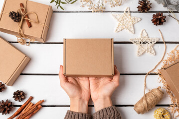 A woman is packing gifts in a craft box. Eco friendly Christmas. Wasteless.