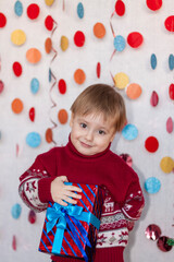 Portrait of a cute boy with a gift in his hands. Children's emotions. Christmas and new year.