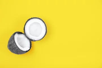 Draufsicht auf halbierte, reife, grau gefärbte Kokosnuss auf hellgelbem Hintergrund. Trendfarben 2021 Jahr. Sommerkonzept. Minimale flache Lage. Platz für Text © greola84