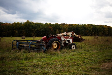 Farmer's tractor sitting in a hay field. Farming and agriculture in the country during the Autumn season in Ontario, Canada.