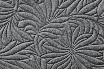 Texture of genuine leather embossed floral pattern close-up, trendy grey color. Modern natural background