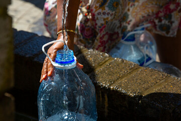 People collecting natural spring water in drought  water crisis with 5 litre plastic water bottle at Newlands natural spring Cape Town South Africa