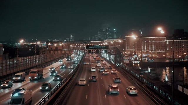 Car traffic on the Andreevsky bridge over the Moscow river at night in Moscow, Russia 27.11.2020