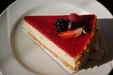 vanilla cheesecake with berries on a white plate sunny photo. 