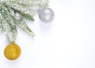 Christmas decorative silver and gold balls on a spruce branch in the snow, on a white...
