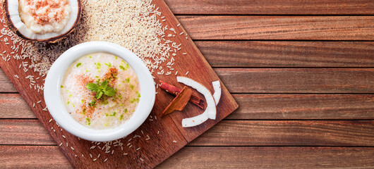 Sweet rice in bowl on rustic wooden background..Coconut stuffed with rice pudding, rice and cinnamon scattered on wooden background..Top view.