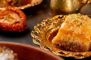 Piece of Turkish baklava in golden arabic plate