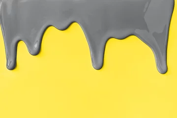 Graue Farbe, die gelben Hintergrund herunterläuft. Farben 2021. © Anna