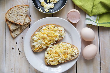 Top view of quick breakfast made of scrambled eggs served on wooden table