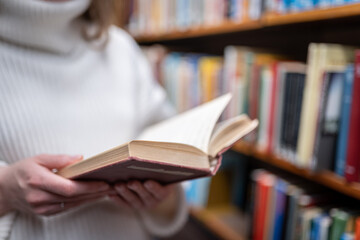 Young woman holding old book in the library