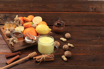 Healthy natural food for flu and colds. Golden turmeric latte and fresh fruit with vitamin C and natural ingredients to strengthen the immune system, protect against viruses, selective focus.