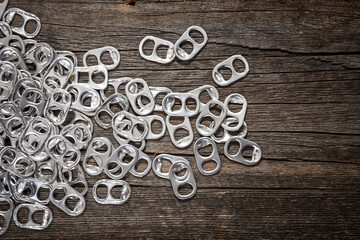 Close up rings pull aluminum of soda or beer can isolate on wood background.