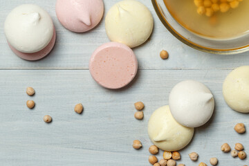 chickpea seeds, aquafaba and colored meringues close-up on a gray wooden background, with space.Top view