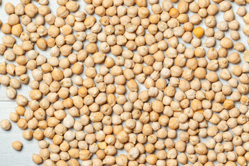 Raw chickpea seeds on a wooden surface. Top view close up