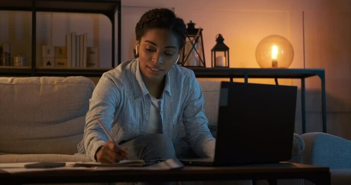 Woman Working On Laptop And Analyzing Documents Late Night At Home