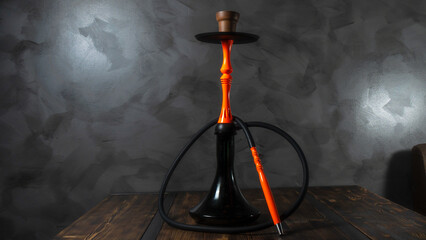 Modern orange hookah on a gray concrete abstract background. Space for text.