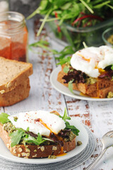 Homemade sandwiches with pesto, green salad and poached eggs