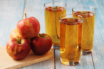 Three glasses with apple juice and ripe apples	

