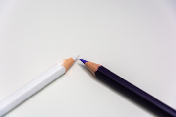 Black and white pencils arranged side by side with white background and space for text