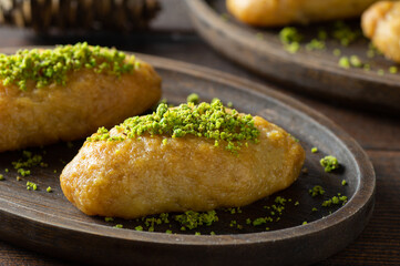 Turkish traditional sherbet dessert kalburabasti on wooden table, dough baked in syrup, handmade dessert concept