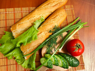 Still life of products - bread, cucumbers, tomatoes, onions, herbs