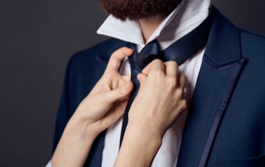 Womens hands tie around the neck of men classic suit model beard